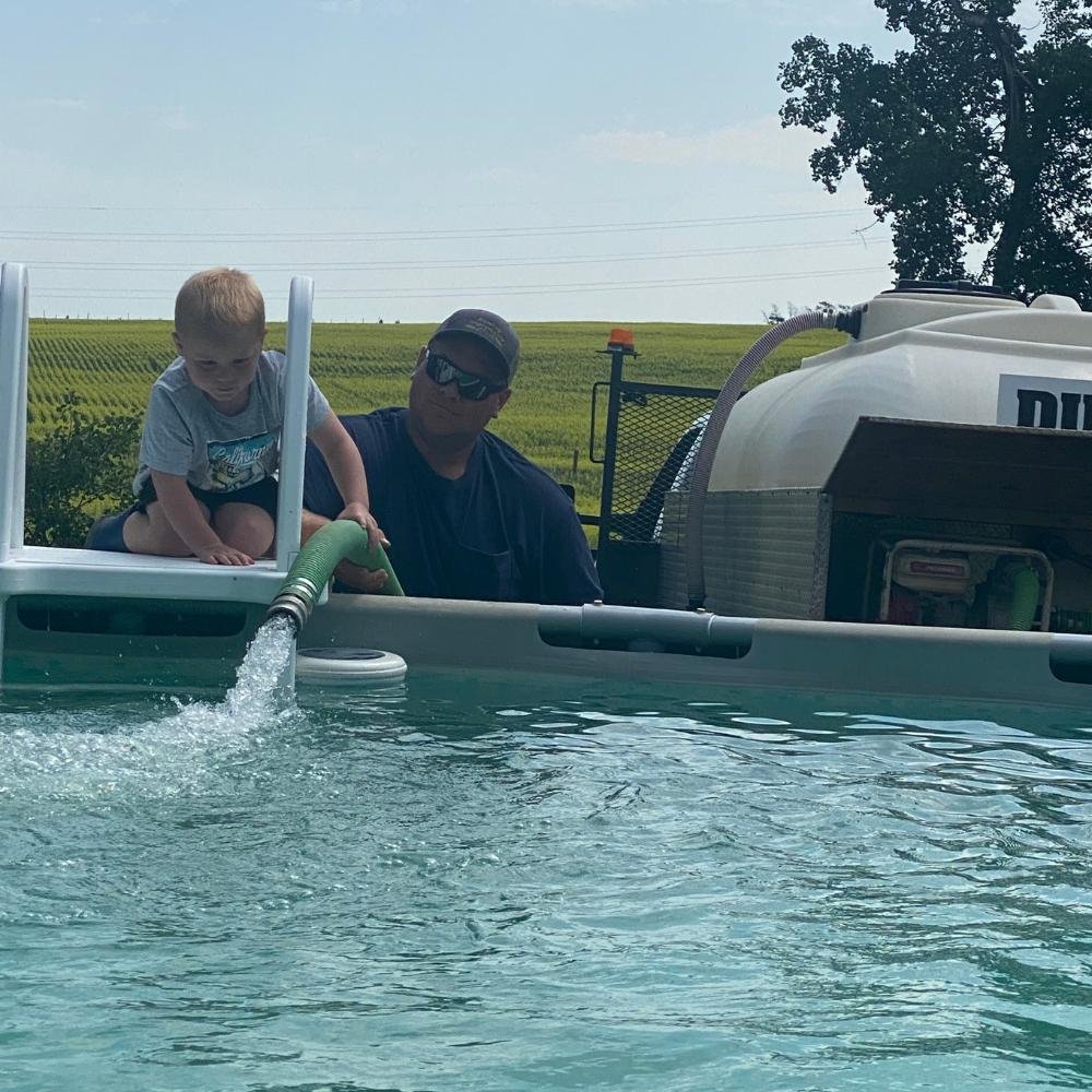 Dunc’s water hauling truck filling a swimming pool on a rural property